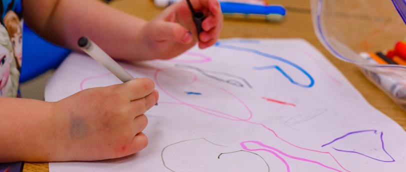 a child is drawing on a piece of paper